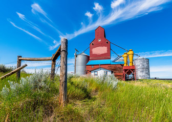 The historic Cadillac grain elevator in Saskatchewan, Canada with fence posts and grass in the foreground