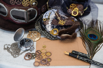 Hats Steampunk or cyberpunk glasses and accessories for women's clothing and an empty card for the inscription lie on a light cracked background. The concept of Victorian romance and Gothic