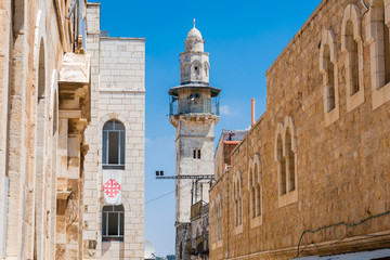 Fototapeta na wymiar View on Minaret from the narrow stone street in Old City Jerusalem