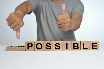 Hand flip wooden cube with word impossible to possible, Personal development and career growth or change yourself concept