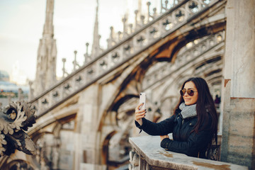 Fototapeta premium girl using her phone while exploring the duomo in Milan Italy