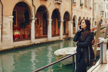 Fototapeta na wymiar girl talking on the phone and taking pictures in Venice Italy