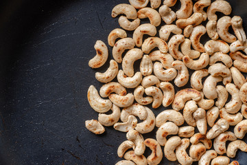 Close-up Roasted cashew nuts and  salt in a pan.Concept Health.