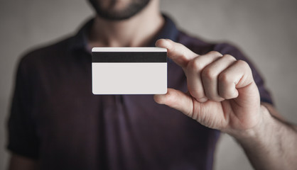 Caucasian man showing credit card.