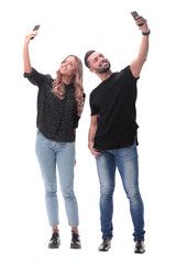 in full growth. smiling young couple taking selfie
