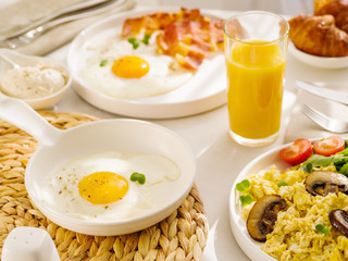 Morning breakfast with egg, bacon and orange juice. Fried eggs sunny side up