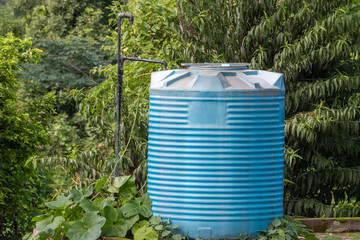 Blue Water Tank covered with trees and Plants.