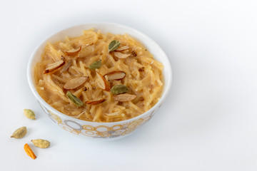 Vermicelli dessert, popular sweet dish know a kheer made with milk and garnish with dry fruits isolated on white background, served in bowl. Selective focus. Top view.