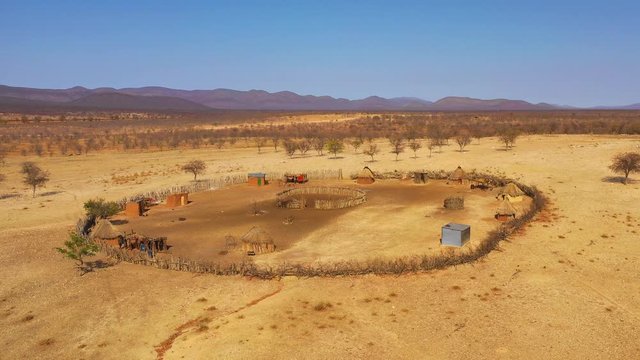 Beautiful aerial over a round Himba African tribal settlement and family compound in northern Namibia, Africa.