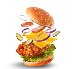 Burger with flying ingredients. Delicious monster Hamburger cheeseburger explosion concept flying ingredients - obrazy, fototapety, plakaty