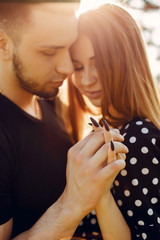 Cute couple in a park. Lady in a black dress. Guy in a black t-shirt.