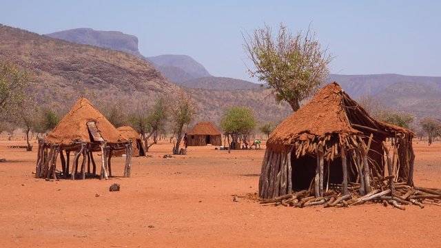 Small poor African Himba rural village on the Namibia Angola border with mud huts, goats and children.