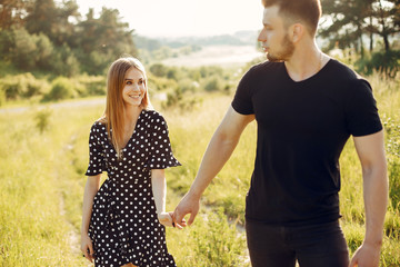 Cute couple in a park. Lady in a black dress. Guy in a black t-shirt.