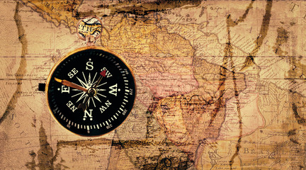 Fototapeta na wymiar Old compass on antique cracked world map. Vintage still life. Top view