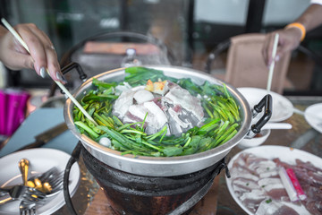 The blurred background of grilling food (pork pan) smokes with the evening atmosphere surrounded by nature, happiness while traveling.