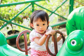 Portrait of baby 1-2 years old. Happy Asian child girl playing toys at the playground. She smiling. kids and sport concept.