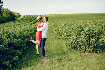 Couple in a field. Girl in a red dress. Man in a white shirt