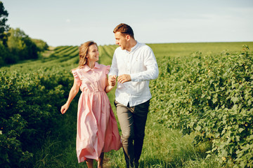 Fototapeta na wymiar Couple in a field. Girl in a pink dress. Man in a white shirt