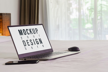 Mockup laptop on the bed. Relax and chill. Blank mock up screen notebook for blog, website, social media. Working in the bedroom background concept.