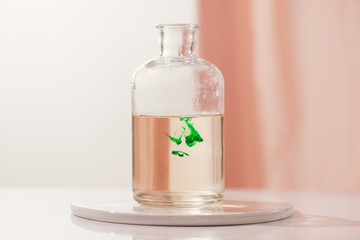Green color dropping into a bottle of water