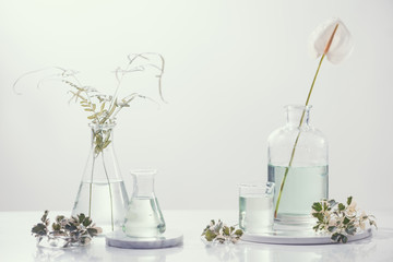 Perfume oils concept. Laboratory glassware with infused floral water on table