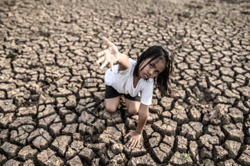 The girl sat elsewhere, hand to the sky to ask for rain on the dry ground,global warming