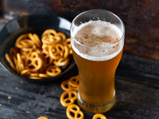 a glass of wheat beer with a traditional snack salty pretzel