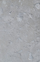 Urban concrete wall background with grooves and bubbles. Cement gray wall. Urban and industrialization art concept. Texture like concrete, stone, cement, plaster.. Poster mockup. Сloseup studio shot.