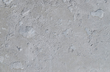 Urban concrete wall background with grooves and bubbles. Cement gray wall. Urban and industrialization art concept. Texture like concrete, stone, cement, plaster.. Poster mockup. Сloseup studio shot.
