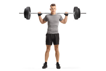 Young guy holding weights on shoulders