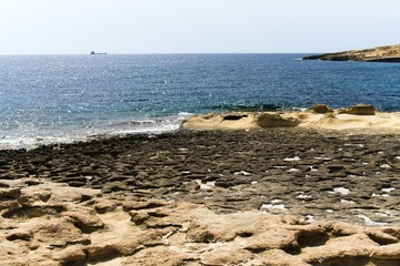 View of the rocky coast of the island of Malta near the city of Marsaxlokk.