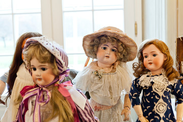 antique porcelain doll in vintage dresses in a blurred light