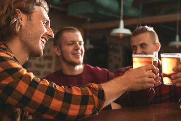 Friends drinking fresh beer in pub