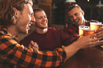 Friends drinking fresh beer in pub