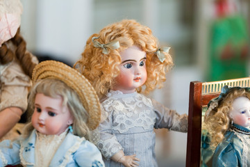 antique porcelain doll in vintage dresses in a blurred light