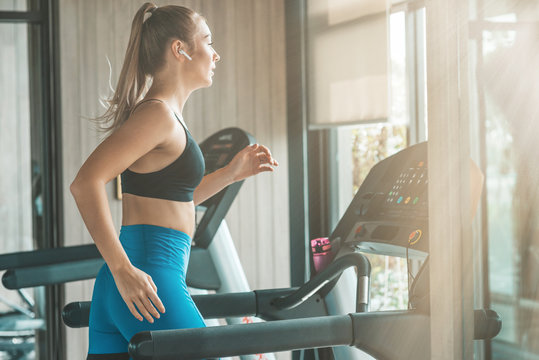 Commit to be fit. Young woman workout in gym. Healthy lifestyle concept. Copy space on the right side