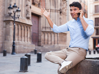 modern guy walks in city and communicates on smartphone