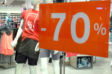 Window of Boutique With Mannequin and Sign Advertising Sale for Sport Clothes.