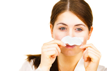 Woman applying pore strips on nose