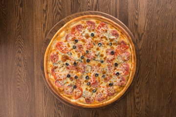 Pizza pepperoni with olives isolated on wooden background
