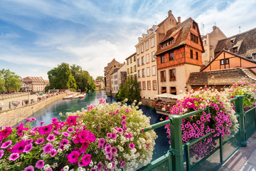 Fototapeta na wymiar Colorful and fabulous landscape with decorative flowers and the river Ill and half-timbered houses in Strasbourg, France