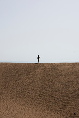 Fototapeta na wymiar Silueta de una chica en una duna del desierto
