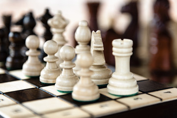 Close up of chessboard with classic wooden pieces with selective focus