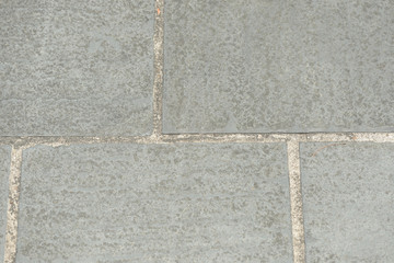 Fototapeta premium Gray paving slabs closeup, top view. Abstract background