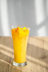 Mango Boba Bubble Milk Tea with bubble topping for tea or other beverage on the wood table with copy-space for textures and wall Natural light background