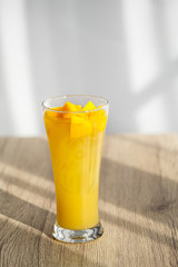 Mango Boba Bubble Milk Tea with bubble topping for tea or other beverage on the wood table with copy-space for textures and wall Natural light background
