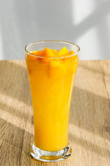 Mango Boba Bubble Milk Tea with bubble topping for tea or other beverage on the wood table with copy-space for textures and wall Natural light background