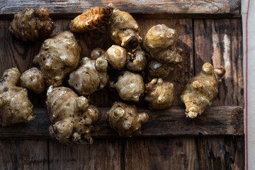 Whole ans sliced Jerusalem artichokes on a cutting board