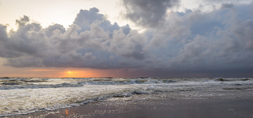 Panorama of a sunset and storm clouds over sea. Scenic view at the beach.