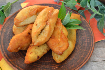 Pies on a old brown ceramic plate and mint, on old wooden table